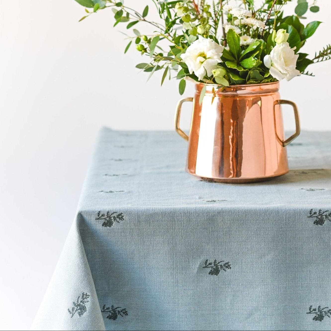 Blue-green linen tablecloth with delicate embroidered fleur motifs