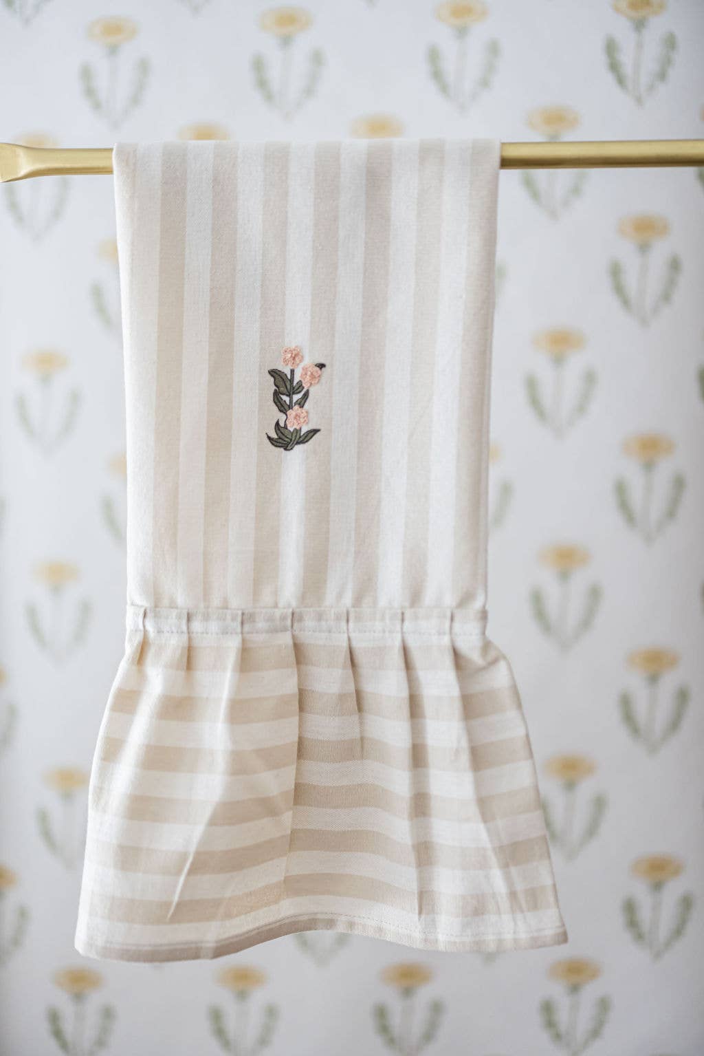Beige and cream striped dish towel with ruffle edge and embroidered flowers