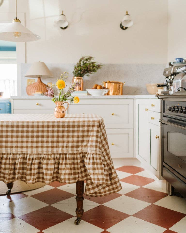 Kitchen with a checkered tablecloth on a table and a checkered floor.