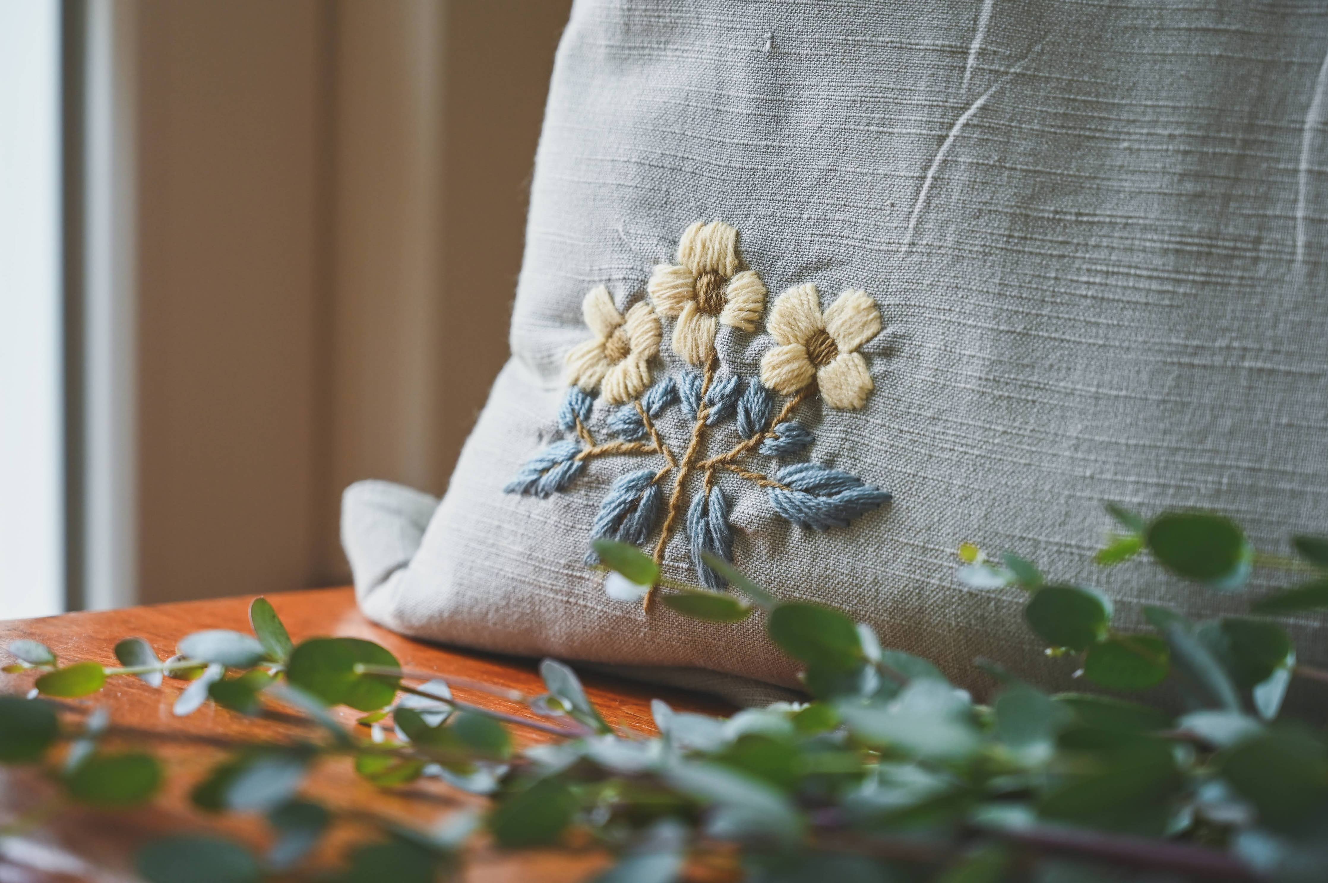 Decorative pillow cover with five embroidered flowers and brass zipper