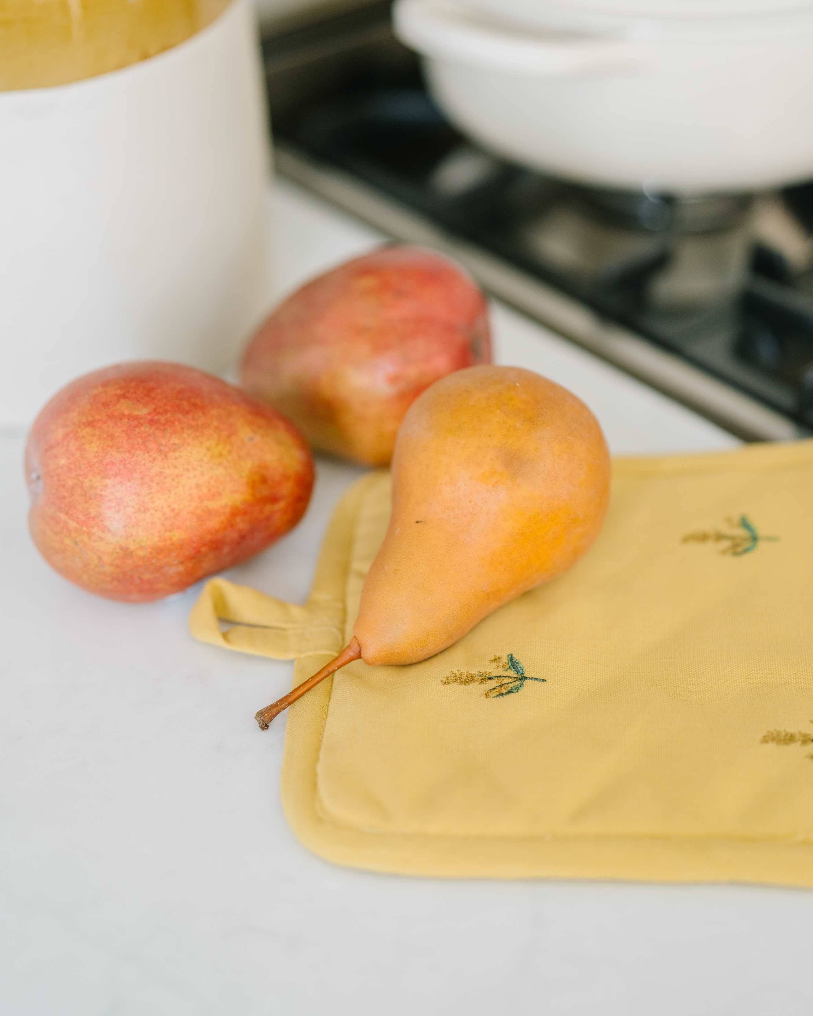 Pears on a yellow towel with a blurred kitchen background