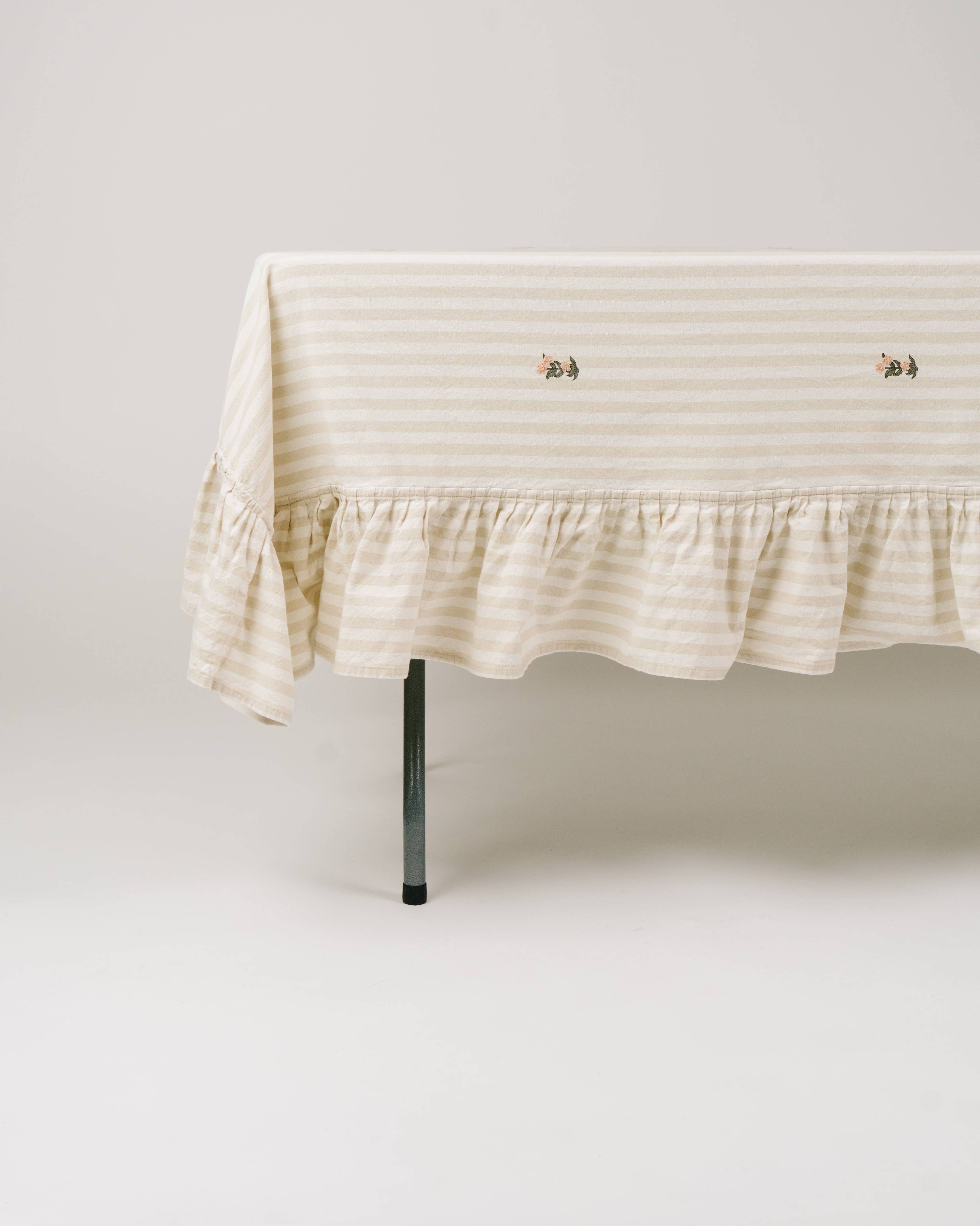 Cottage-inspired table setting with ruffled striped tablecloth