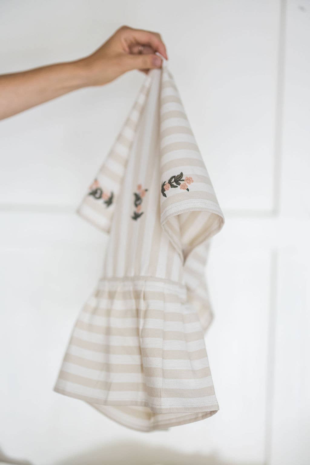 Decorative kitchen towel with beige stripes and floral accents