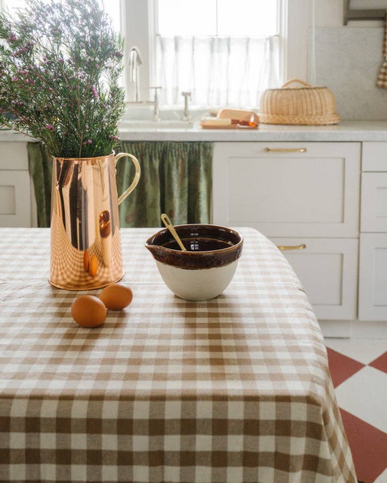 Warm kitchen table styled with ruffled gingham tablecloth