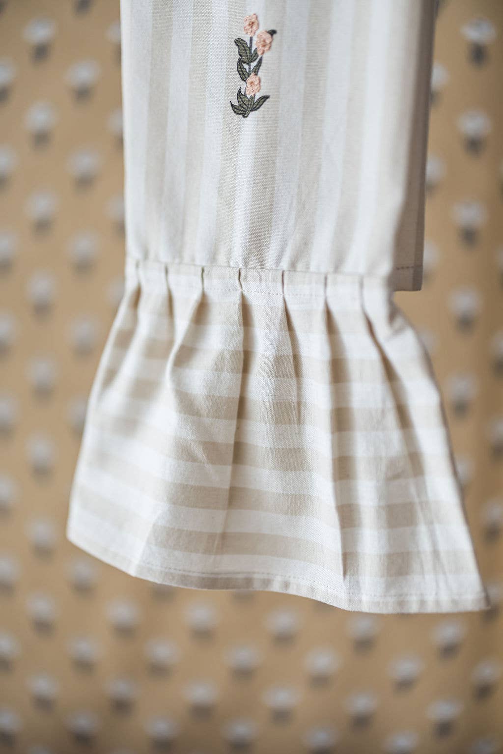 Close-up of ruffle trim and embroidered detail on dish towel