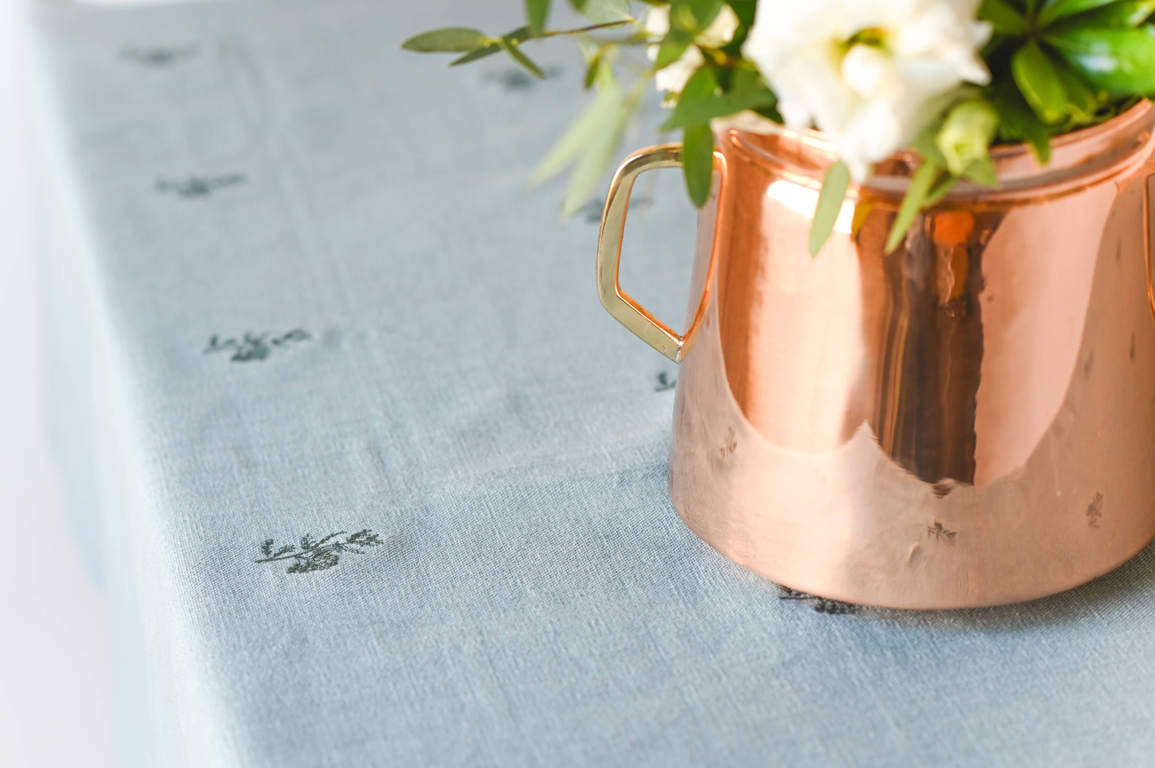 French-inspired table setting with blue-green linen tablecloth