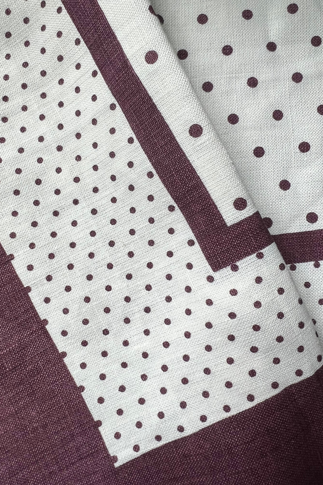 Close-up of fabric with polka dot pattern and a solid color stripe.