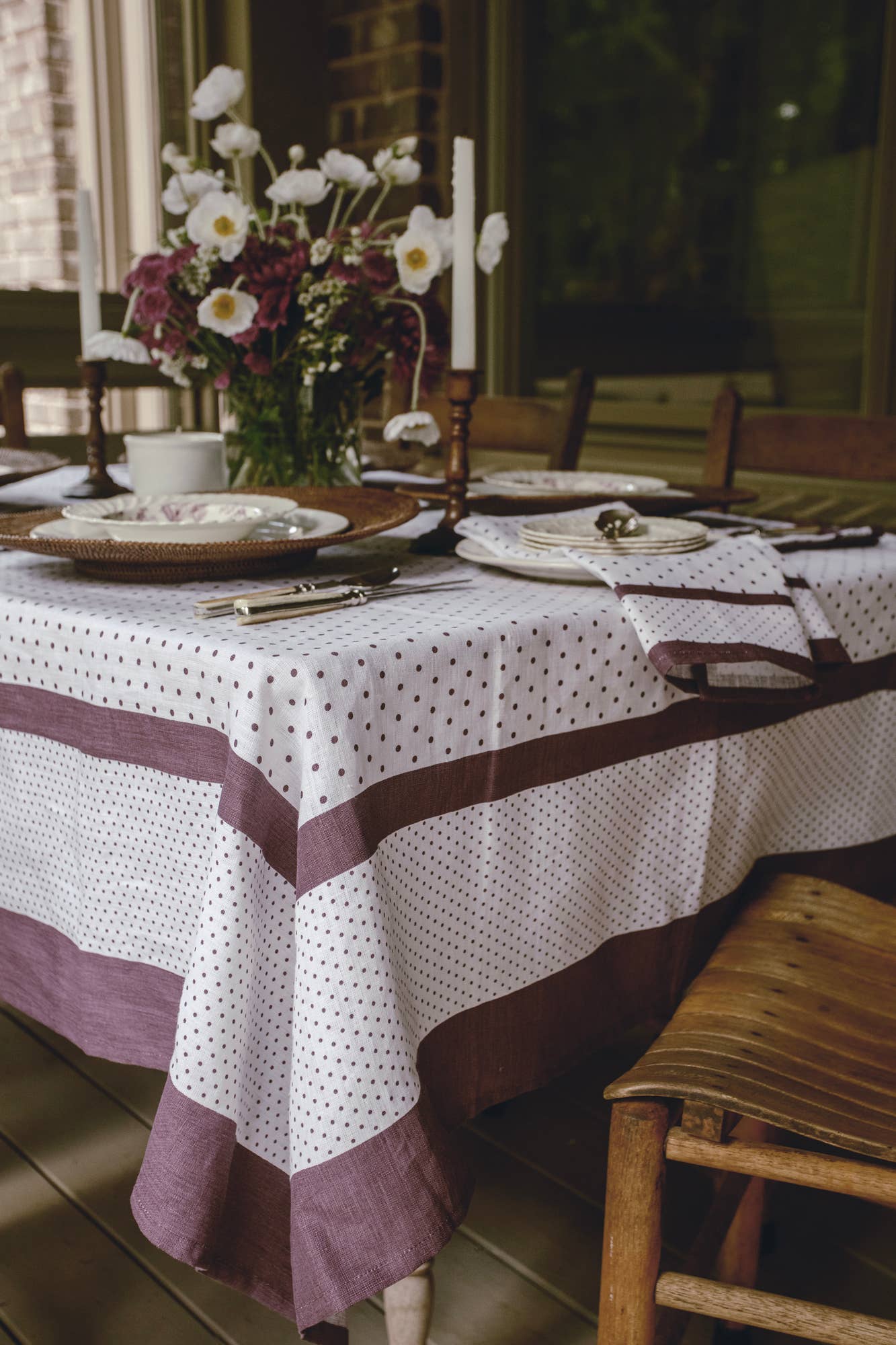 Dining table set with a polka dot tablecloth and floral centerpiece.